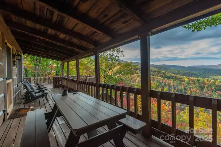 Covered porch with a picnic table looking out at the fall ridges