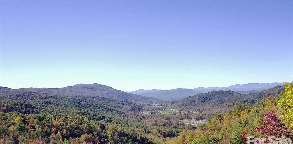 Layered blue ridgelines above a wooded valley on a clear fall day